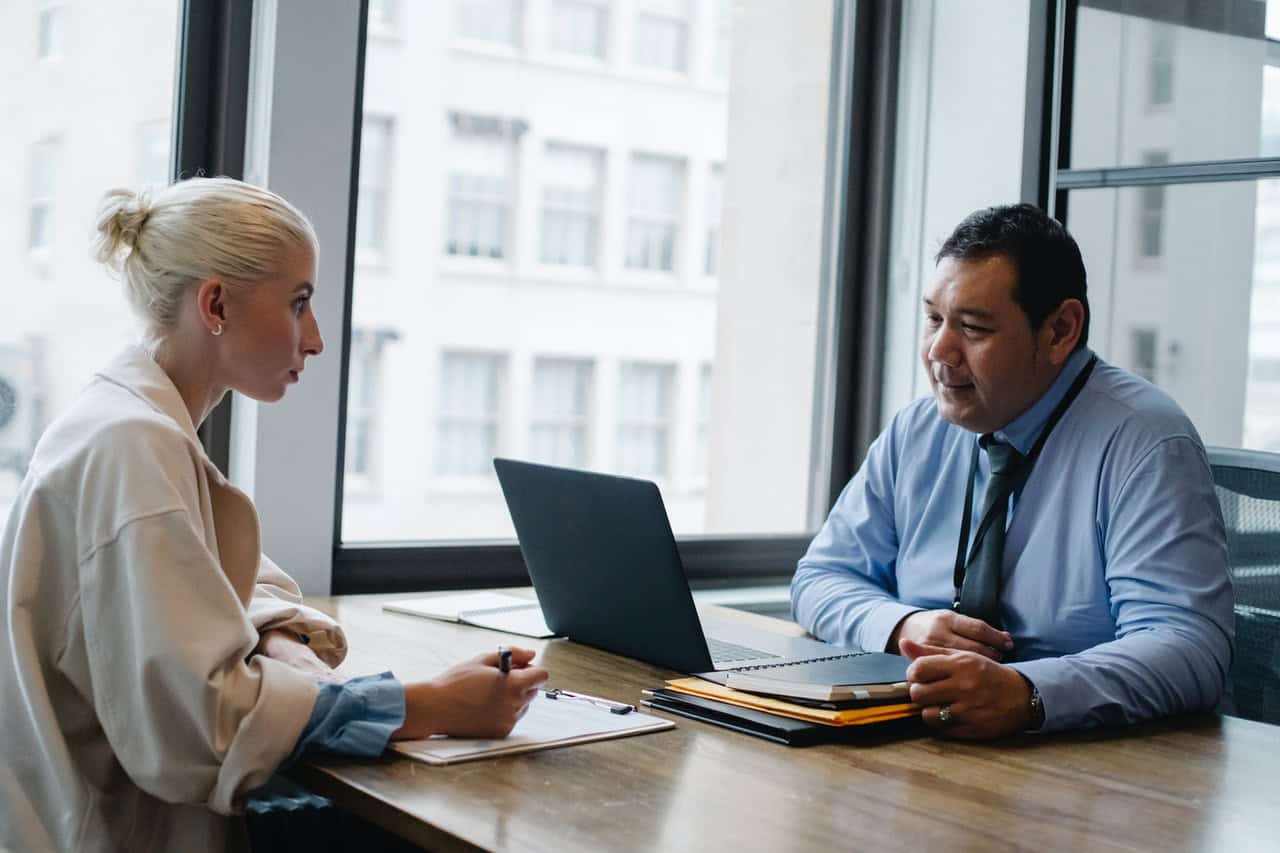 a lady is giving interview in front of job board