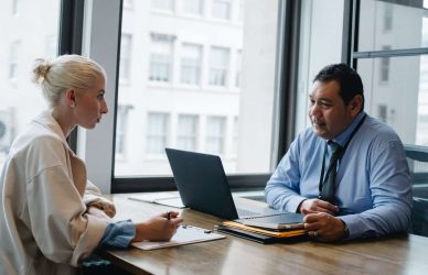 a lady is giving interview in front of job board